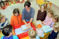 Jutta Frings zeigt den Kindern, wie mit dem Rahmen Papier aus dem grauen Brei geschöpft wird.  Foto:  BUSCH